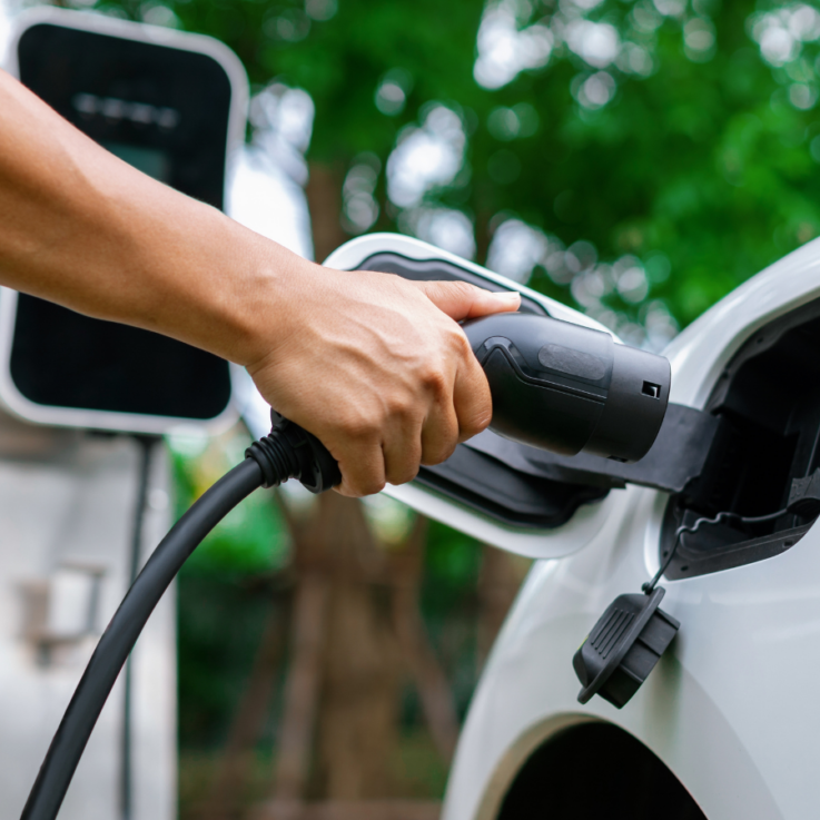 An electric vehicle being plugged in to charge